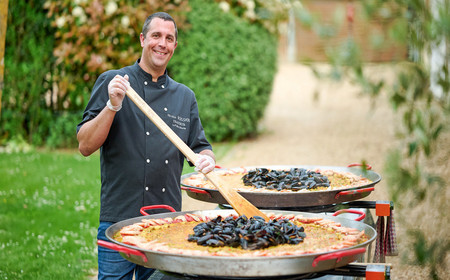 Nicolas Boissière prépare à manger dans des poêles géantes.