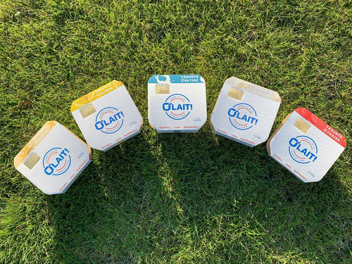 Dos pots de yaourts O'lait, en arc de cercle dans l'herbe