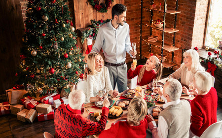Des paquets cadeaux et un sapin prêts d'une famille fêtant Noël.